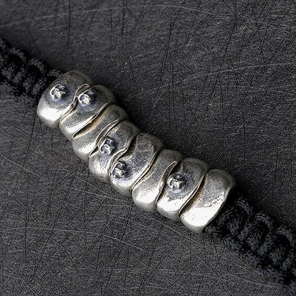 Pulsera tejida con cordón de paracaídas de plata y armadura de calavera