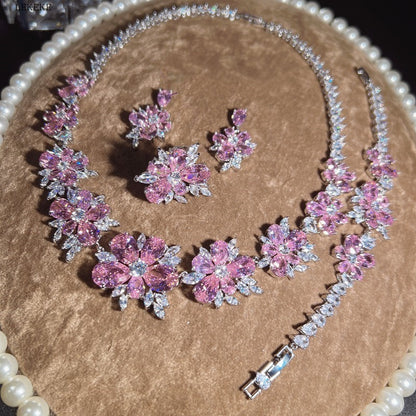 Ensemble de quatre bagues avec collier, boucles d'oreilles, bracelet et fleur en zircone