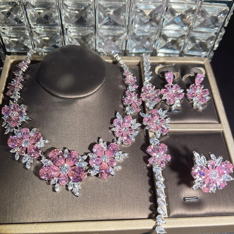 Ensemble de quatre bagues avec collier, boucles d'oreilles, bracelet et fleur en zircone