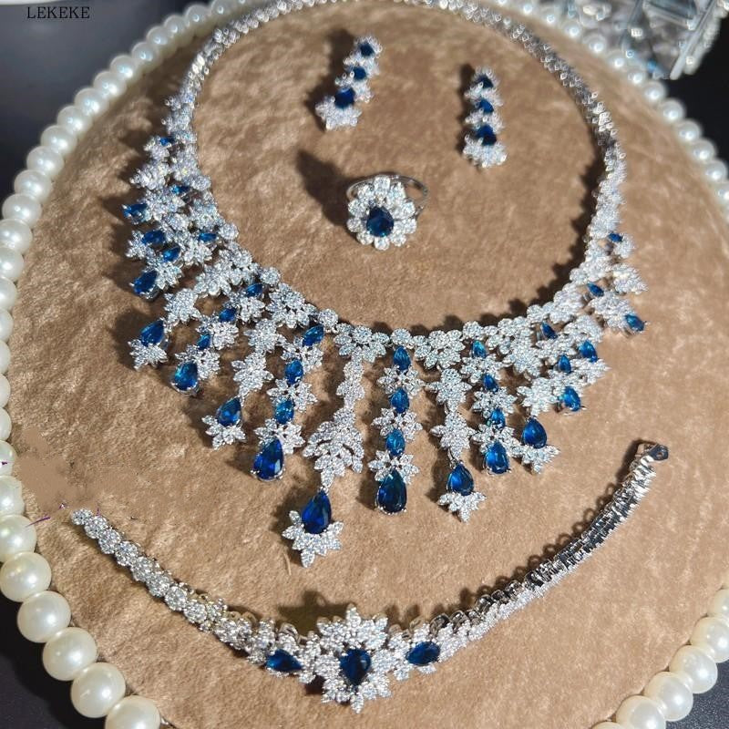 Conjunto de cuatro piezas de collar, pendientes y pulsera con borlas y circonitas de color azul con diamantes de imitación